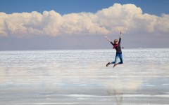 Jumping girl in flooded Salar de Uyuni, Bolivia