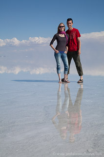 Couple posing in flooded Salar de Uyuni with reflections