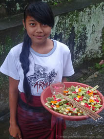 Balinese girl holding flower and incense offerings