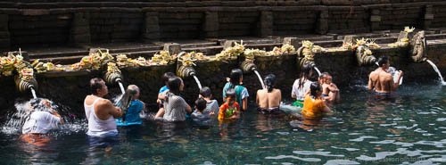 People bathing in the holy spring water at Tampaksiring Temple in Bali