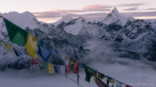 Dawn view of the Himalayas through prayer flags